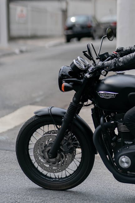 Close-up of a classic black motorcycle on a city street, perfect for urban adventure themes.