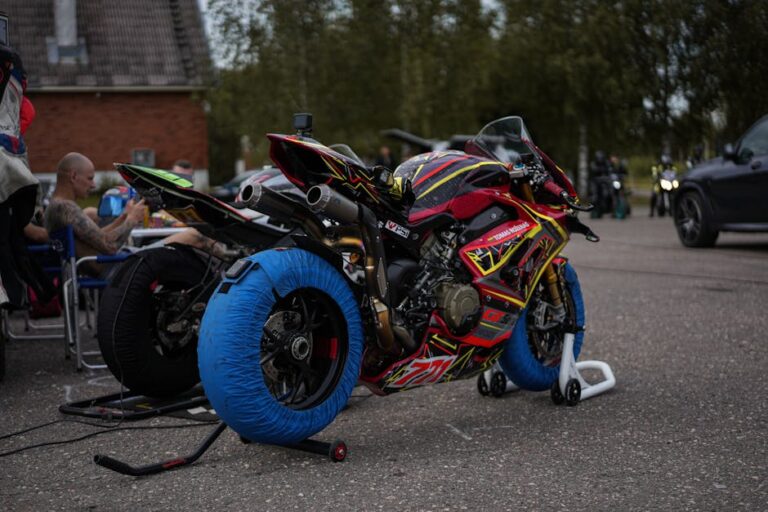 Ein lebhaftes Rennmotorrad mit Reifenheizungen in der Boxengasse, bereit für das Rennen.