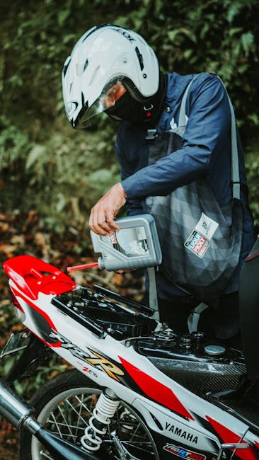 Person pouring engine oil into a Yamaha motorcycle in Jakarta, Indonesia, showcasing routine maintenance.