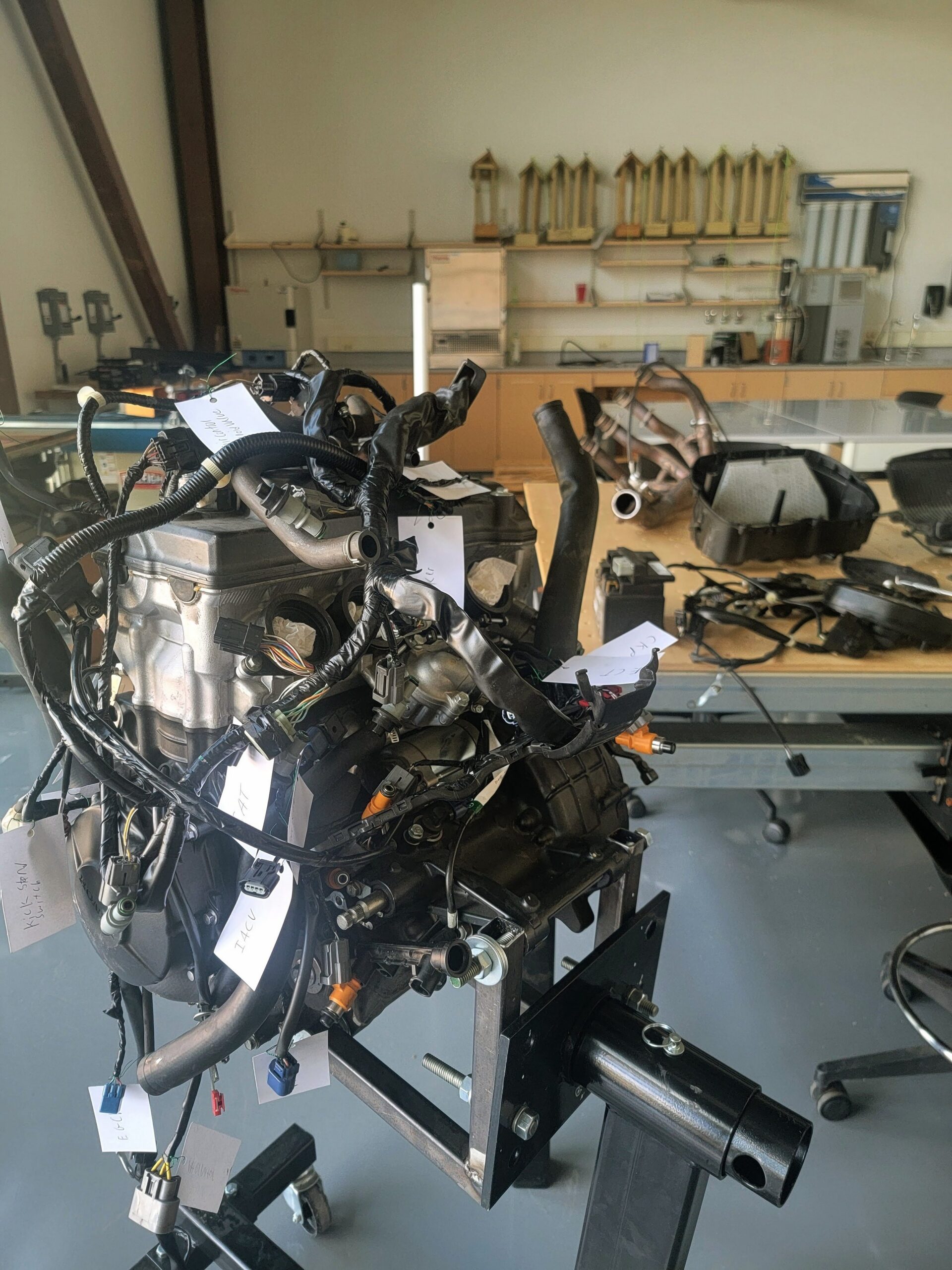 Worker fitting a front wheel to a motorcycle on an assembly line