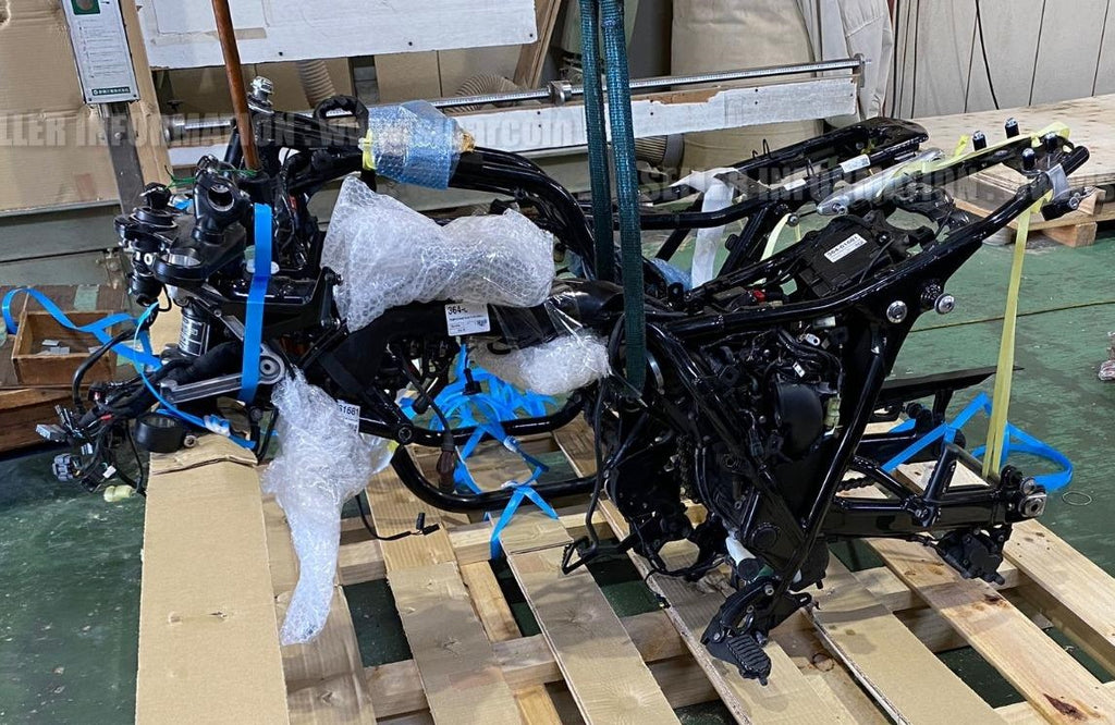 Crated motorcycle components stacked in a warehouse awaiting assembly