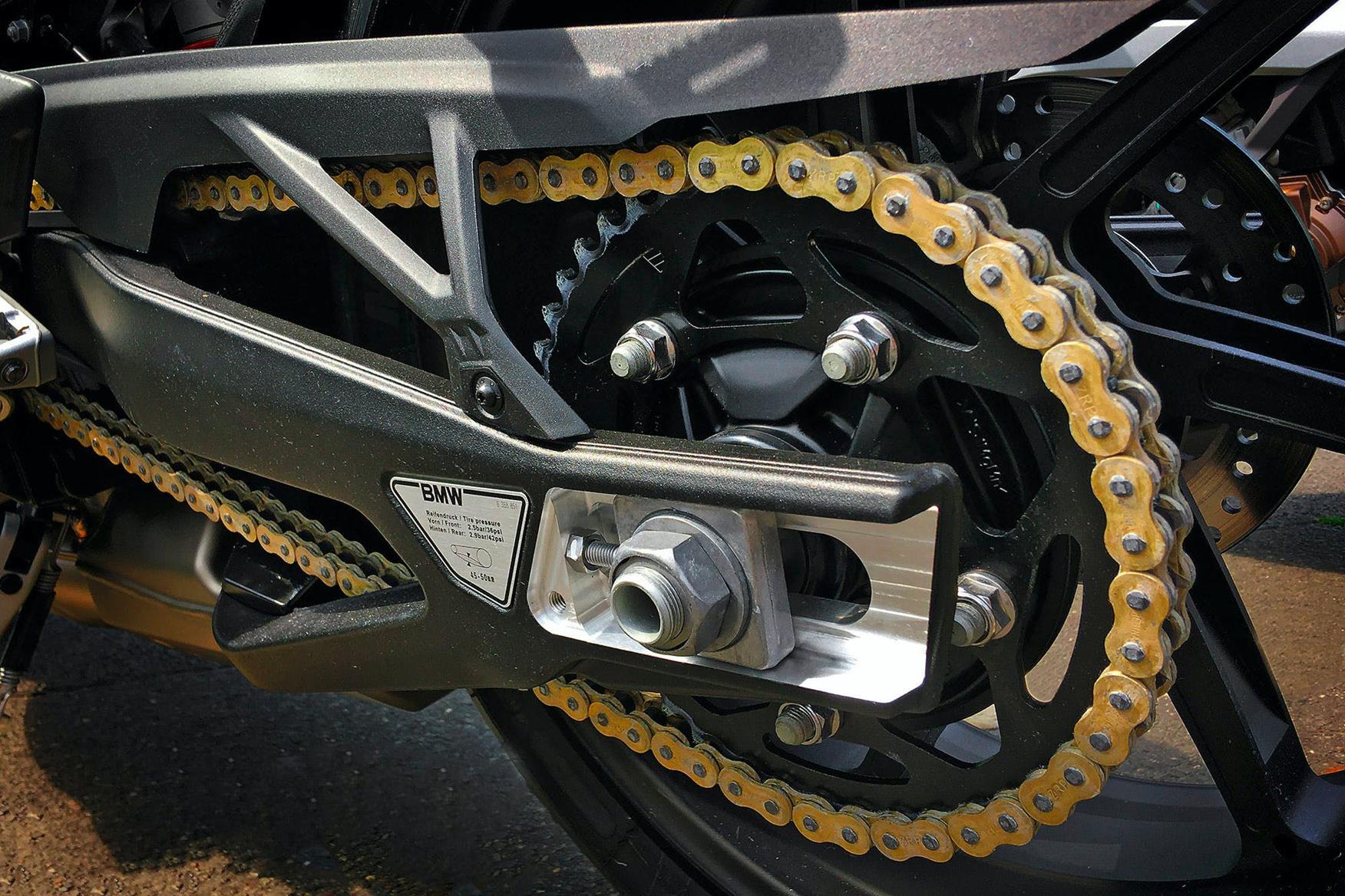 Close-up of a motorcycle chain running over a rear sprocket