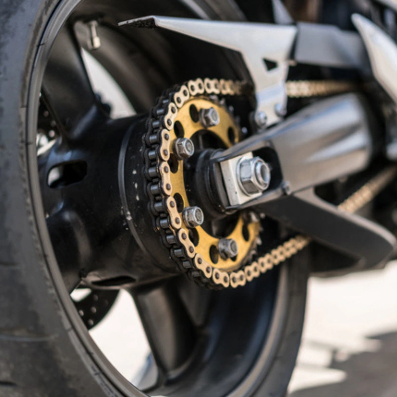 Close-up of a motorcycle chain running over a rear sprocket