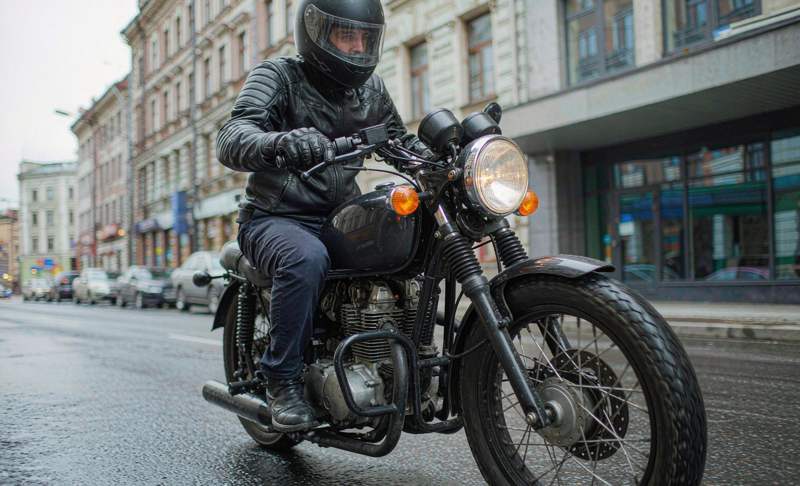 Rider on a cafe racer riding through a city street