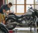Técnico realizando una inspección previa a la entrega en una motocicleta con una lista de verificación en un panel de cartón