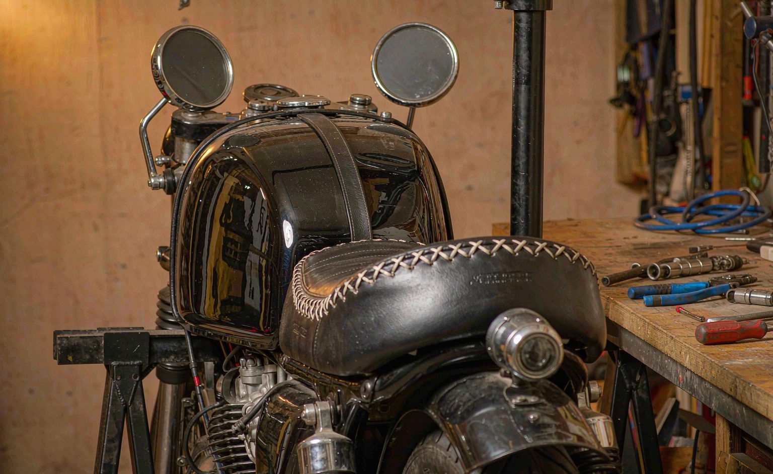 Cafe Racer Tank And Seat Detail Close-up of a cafe racer fuel tank and stitched seat detail in a workshop